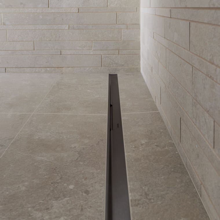 Vanduo nuteka per elegantišką nerūdijančio plieno profilį. Vanduo nuteka per elegantišką nerūdijančio plieno profilį.