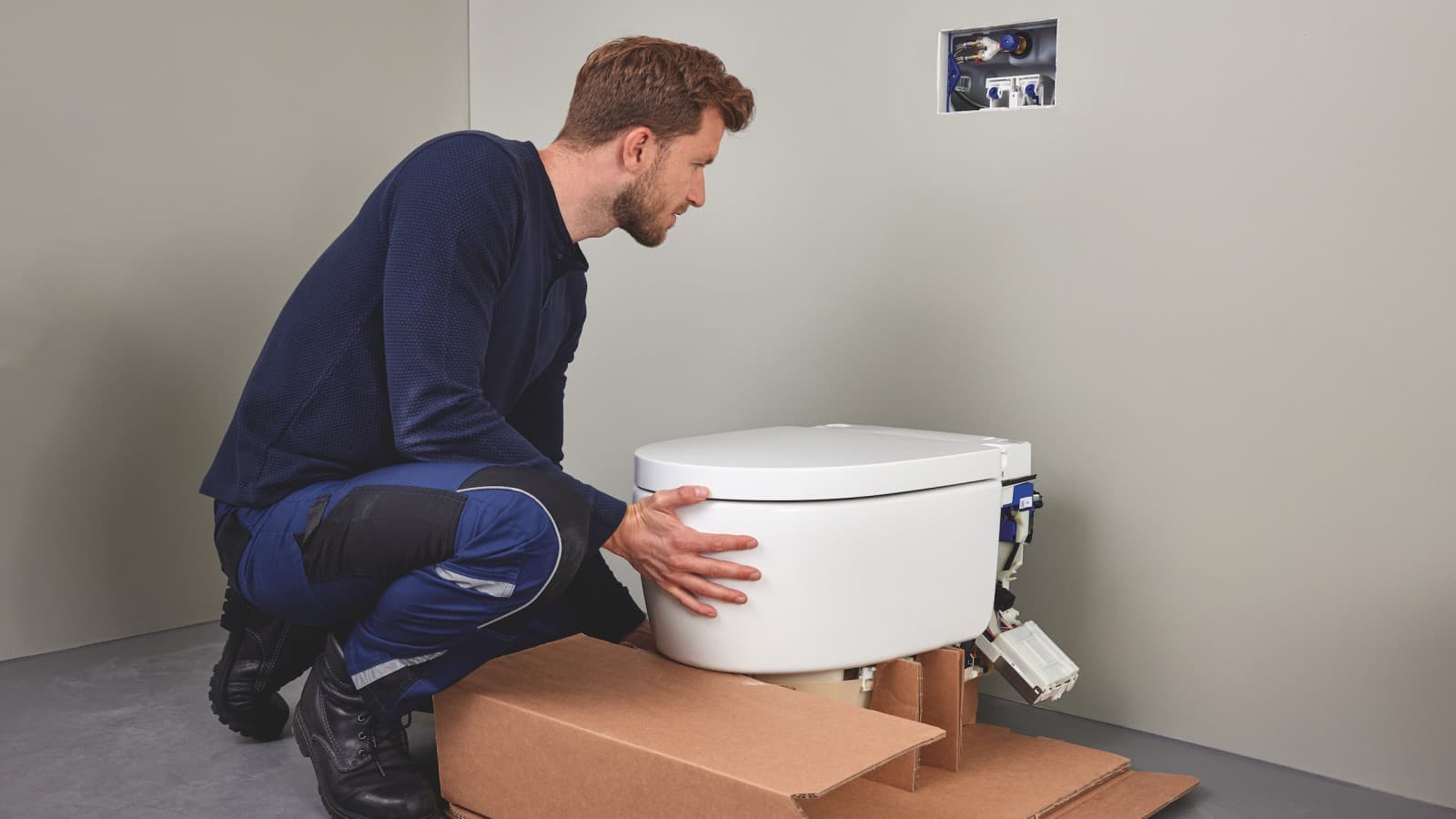 Sanitarinės įrangos specialistas įrengia Geberit AquaClean Sela WC puodą su apiplovimo funkcija Sanitarinės įrangos specialistas įrengia Geberit AquaClean Sela WC puodą su apiplovimo funkcija